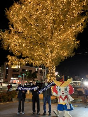 イルミネーションが施されたメタセコイアの木の前にいる、左から世利町長、名古選手、湯澤選手、シメッチャ