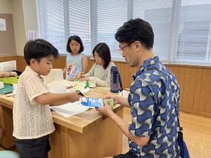 親子で一緒に牛乳パックを切る様子